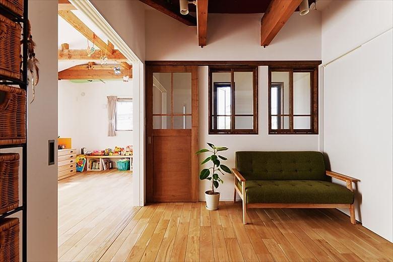 今回のリノベーションで新たに設けた2階のリビング。階段室には西からの光を取り込む内窓を設置した。「小さいながらも気兼ねなく寛げるので気に入っています」とNさん。手前にトイレと造作洗面台も新設した
