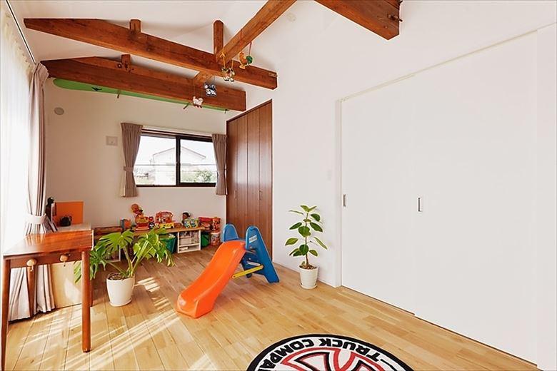 2階の間取りを再構築して生まれた子世帯の居室。まだお子様が小さいため、夜はここで家族そろって寝ているそう。天井は勾配を活かし、開放感を高めている。床はナラの無垢フローリング、2階の壁は漆喰塗り仕上げ