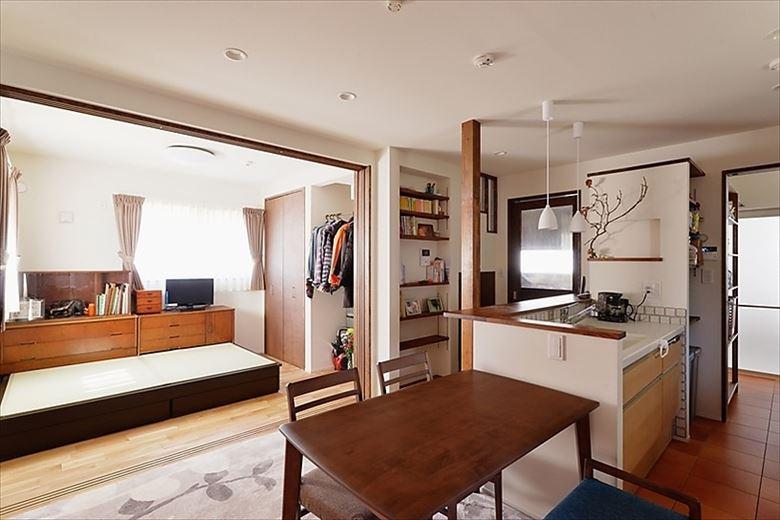 閉鎖的だったキッチンは壁を取り払ってII型に。玄関ホールの一部を取り込んで、さらに空間の広がりが生まれた。居間として活用していた和室は撤去。コンパクトな洋室としてお父様の寝室に。生活時間帯が異なる子世帯と程よい距離を置いたのでゆっくりと休むことができる