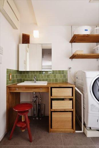 既存の洗面台は撤去して、奥様が選ばれたグリーンの柄タイルとマッチするシンプルな洗面台を造作した。下部のオープンスペースに猫ちゃん用のトイレを置く予定だそう