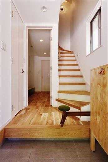 玄関に入ると、框やホール、階段にあしらった無垢材の木目に温かみを感じる。既存の白い靴箱は撤去して木質感ある既製品に交換した。イメージに合う既製品をうまく活用することもコストを抑える工夫の一つだ