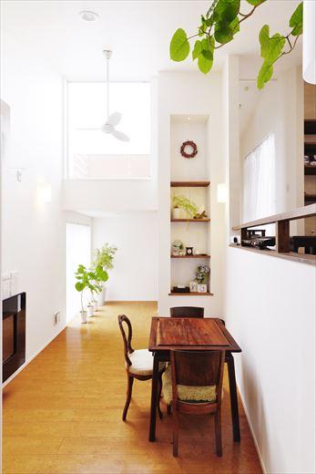 左側、ダイニングスペースに壁掛けのガスストーブを設置。周囲にタイル貼りをあしらった。上部の窓との間の壁をプロジェクターのスクリーン代わりに活用。映像がきれいに映るクロスを選び、全面そのクロスで統一したそう