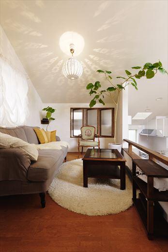 2.5階に位置するリビング。お気に入りのモロッコランプを取り付け、壁や天井に映し出される陰影を楽しみながら寛ぎの時間が過ごせる。ダイニングスペースに投影するプロジェクターの映像が観やすいようにフェンスの高さを下げている