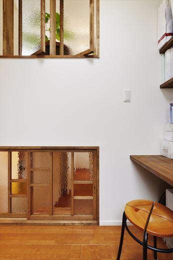 2階のキッチンの背面にある書斎スペース。スキップフロア構造ならではのユニークな開口で、上はリビングとつながり、下は1.5階の寝室とつながる。以前は開口のみだったが、今回のリフォームでそれぞれに室内窓をしつらえた