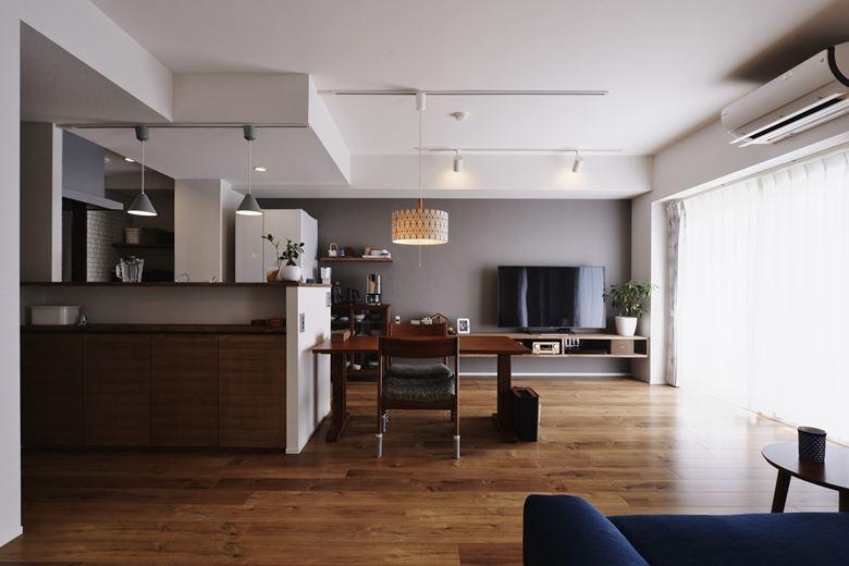 リビングに隣接した和室を撤去して広々としたリビングを実現。仕切り壁や吊り戸棚で囲まれていたキッチンはオープンな対面式に変更し、一体感のあるLDKに。床やアクセントクロスは落ち着いた色を選び、奥様好みの「大人シック」な空間に仕上げた