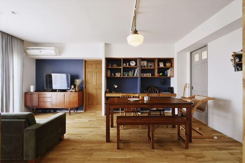 キッチンをずらしたことで一体感のあるリビング・ダイニングを実現。一角にご主人の趣味である音楽制作ができるワークスペースを設置。ゆくゆくは子どもたちの勉強スペースとしても活用できる。右の扉が子ども室、正面が主寝室につながる