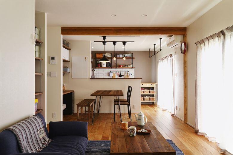 一番日当りのよい場所の2室分をLDKに。既存の窓はそのまま活かし、柱を抜いたところには梁を追加。古材風に仕上げて空間のアクセントとしている。ダイニングの背面にはカウンターを設置。ベンチを共用してPC作業やお子さんの勉強にも使える多目的空間に