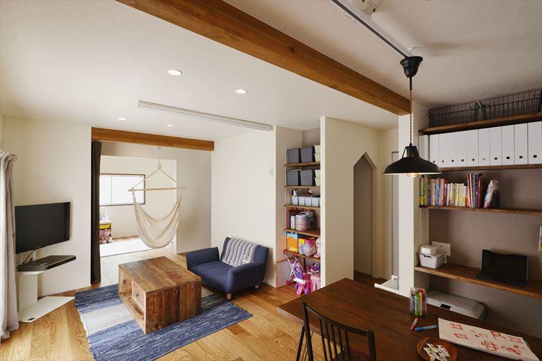 キッチンから居室まで見通せる間取りに。リビングと居室の間の空間に架けたハンモックは子どもたちのお気に入り。リビングにはオープン収納を設置。三角開口で裏動線につながり、玄関からLDKを通らずにファミリークロゼット～洗面室～浴室とつながっている