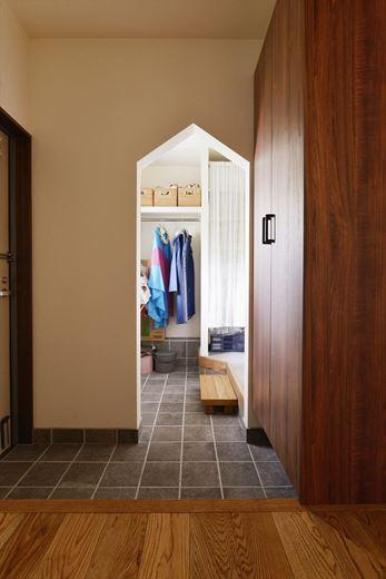 3室のうちのどの玄関を使うかもプランのポイントに。玄関を入って左手が写真の土間収納。右手にトイレを挟んでウォークスルーのファミリークロゼットがある。三角開口で収納と水廻りがつながる裏動線を確保し、3箇所から出入りができるため、人も風も通り抜けられる
