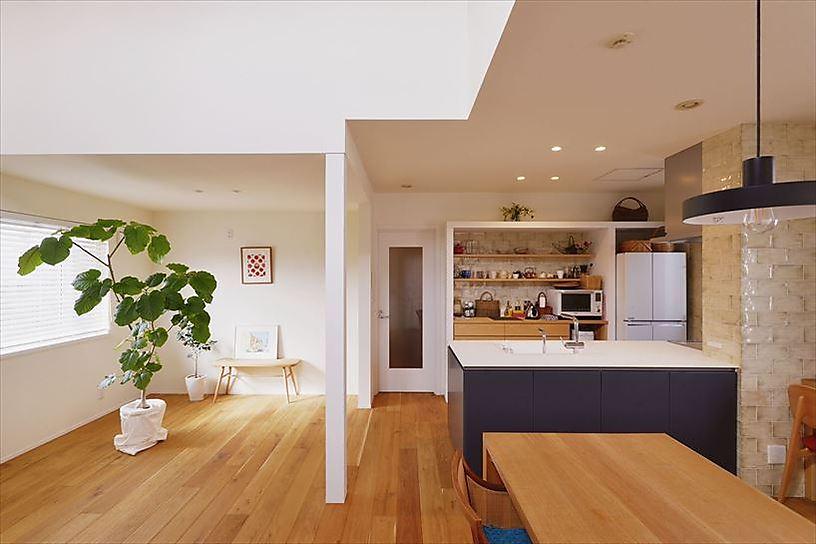 オープンな対面キッチンは空間を引き締めるブラックをセレクト。背面収納は大きな枠を設えることで雑然としがちな雰囲気を払拭。飾り棚に気に入った食器などを並べた様子はまるでお洒落なカフェのよう