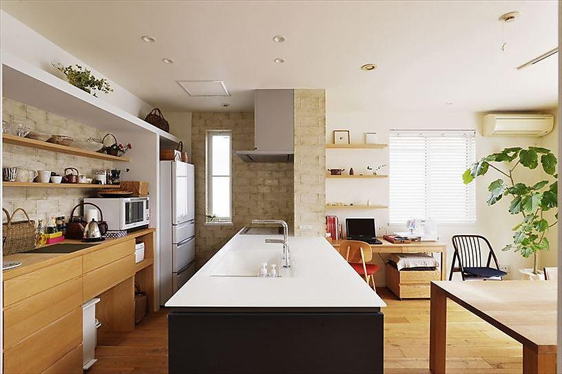 背面収納の下部はどこに何を入れるか、ダストボックスをどこに置くかなど、使い方を丁寧にヒアリングして造作。レンジ周りや棚の背面にはアンティーク調のテクスチャーが特徴的なタイルを選び、上質感を高めている。床は奥様の希望であえて無垢フローリングを採用。