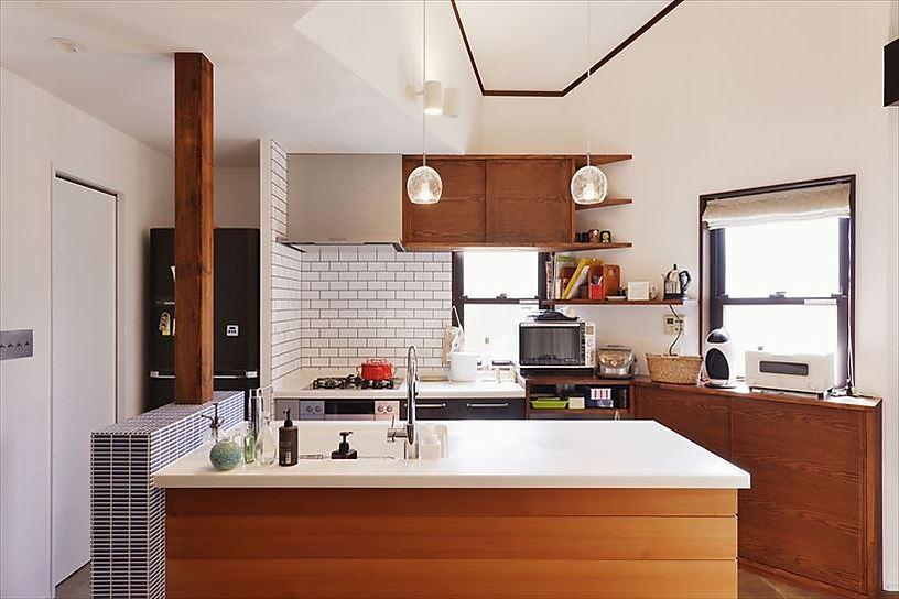 キッチンはシンクとレンジとを分けたII型を採用して家族の様子を見守りながら料理ができるように。既成のシステムキッチンに板張りやタイルをあしらってオリジナル感を出した。背面の収納は複雑な造りに合わせて丁寧に造作。収納力も格段にアップした