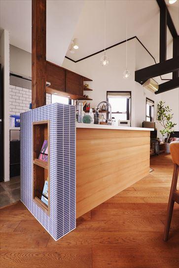 2階の吹き抜け天井はこげ茶の梁が現しになっており、一歩間違うと古民家風に。それはご夫妻の好みとは違っていたため、床は濃い目の色を選んで調和させながらも素材感などでアンティーク調にかたより過ぎない空間デザインを実現しています。キッチンには板張りやタイルをあしらってオリジナルな雰囲気を演出しました。