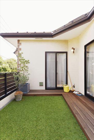 全面がグレーチングだった2階のバルコニーは周囲にウッドデッキを設置。Sさんご夫妻の憧れを叶えた。施工後にご自身で人工芝を敷き詰められ、子どもと一緒に遊べるお庭が誕生した