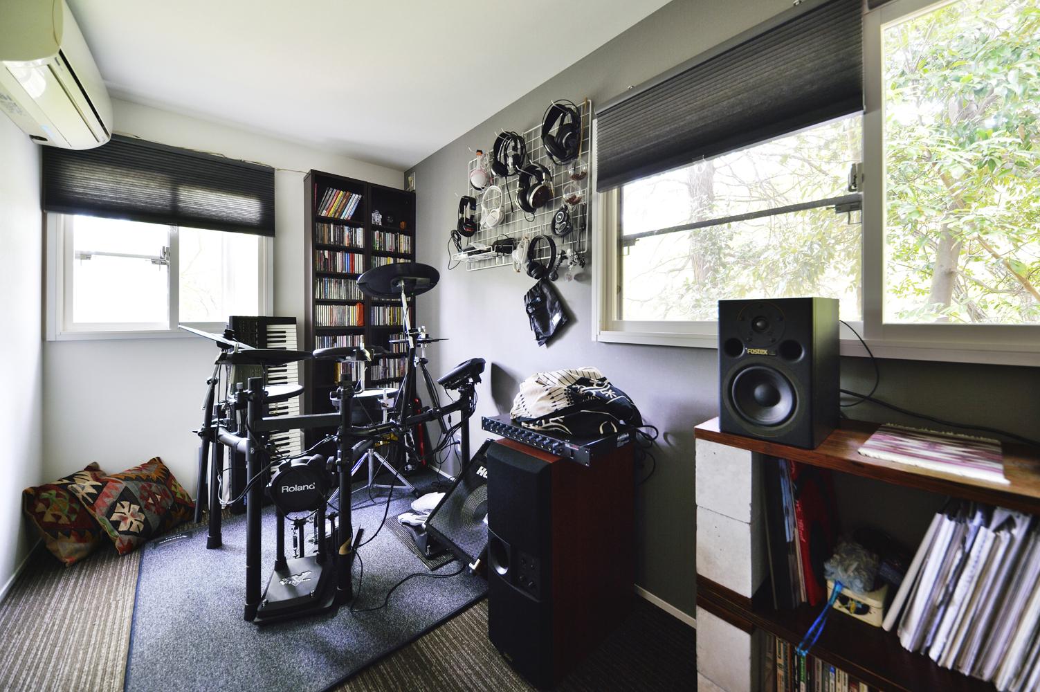 趣味の楽器演奏を楽しめる部屋が欲しいというご希望があったため、キッチンの隣で納戸として使われていた部屋を音楽室に。防音も兼ねた断熱材を入れ、心地よく過ごせるようにした。壁はＬ字型に2面にグレーのアクセントクロス。床はカーペット敷き