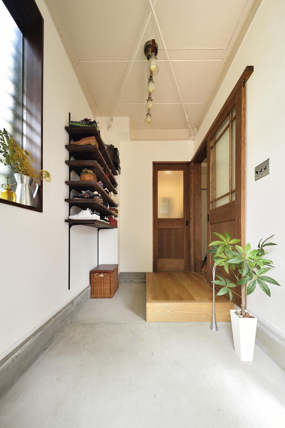 玄関は土間の部分を広げ、モルタル仕上げに。下足収納も高い位置の可動棚にすることで、ベビーカーを置けるスペースを確保した。天井を上げ、出てきたブレースは白く塗装。玄関を入ると、すっきりとした開放的な雰囲気を感じることができる