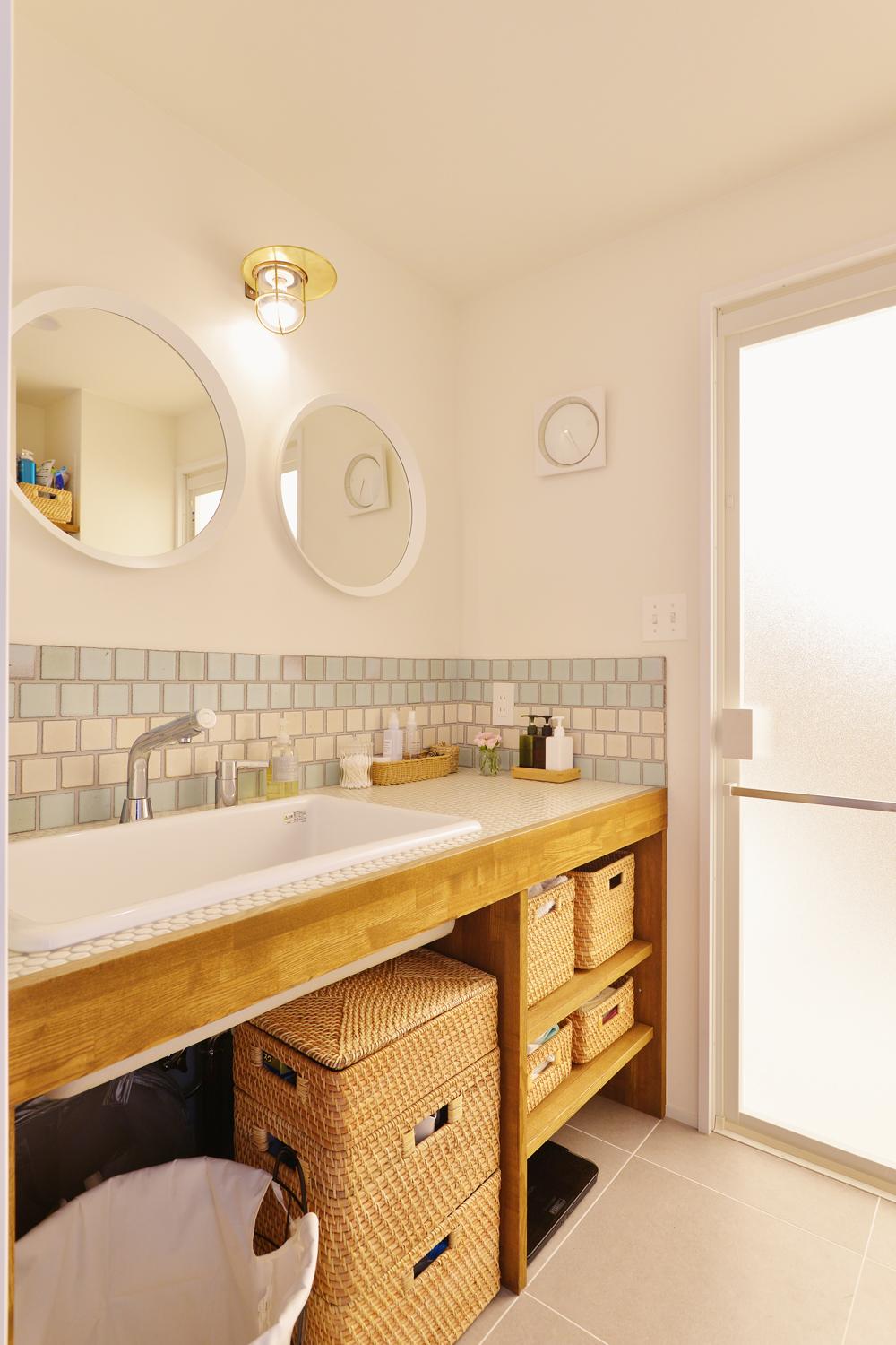 浴室の浴槽の向きを変えることで、洗面室のスペースを広げることが可能に。2人で使える洗面カウンターは造作。扉のないオープンなデザインで使いやすい。2人で並んで立てるように、鏡も2つ設けた