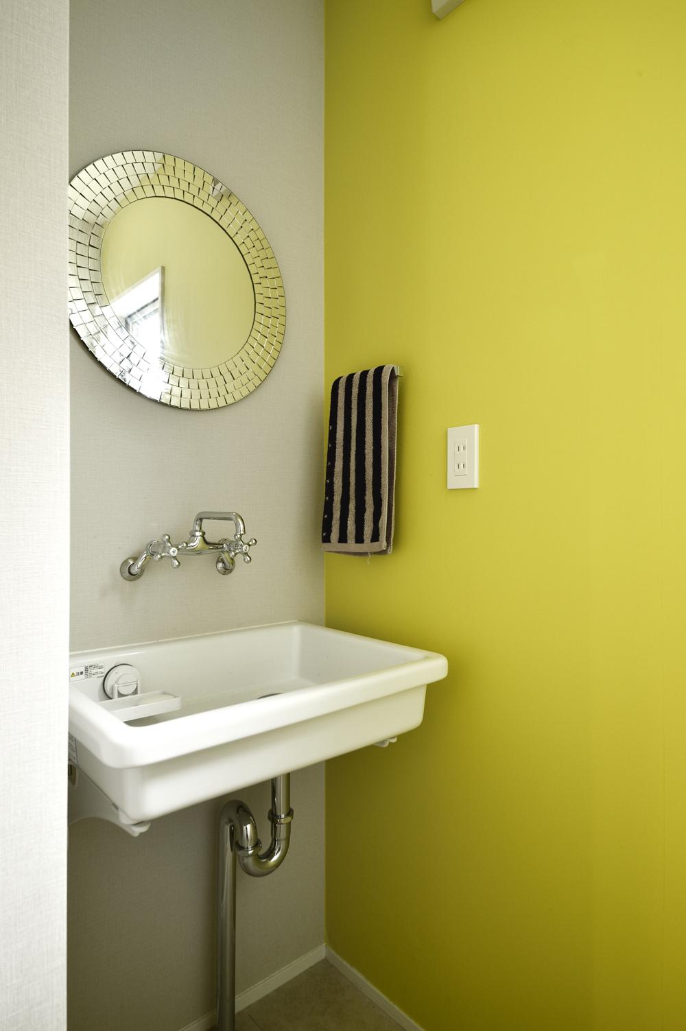 2階洗面室は、トイレの手洗いとして最小限のスペースに変更。リビングから見える壁は、キリッとした印象の明るいライムグリーンのクロスで空間のアクセントに。手洗いスペースから続くトイレのクロスも同じ色