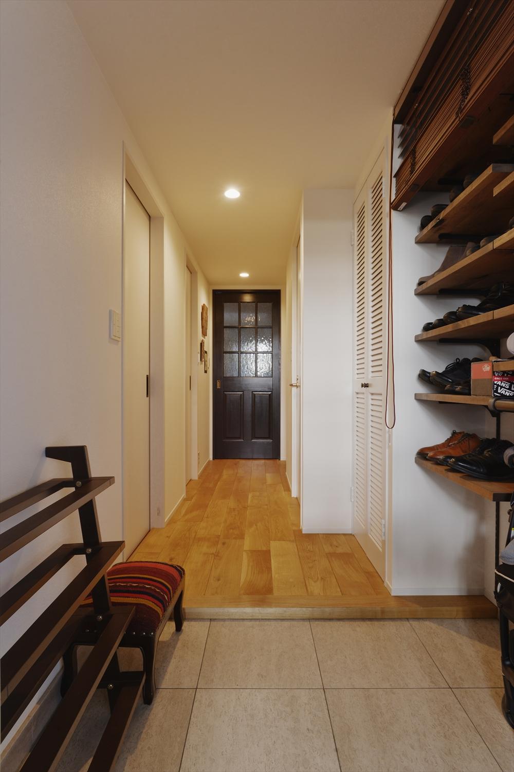 玄関はホールに飛び出していた収納を取り払い、シューズボックスをオープン棚に変えて開放感を演出。以前よりもずっと広がりが感じられる空間となった。棚部分にはウッドブラインドを取り付けたので、来客時には隠すことができる