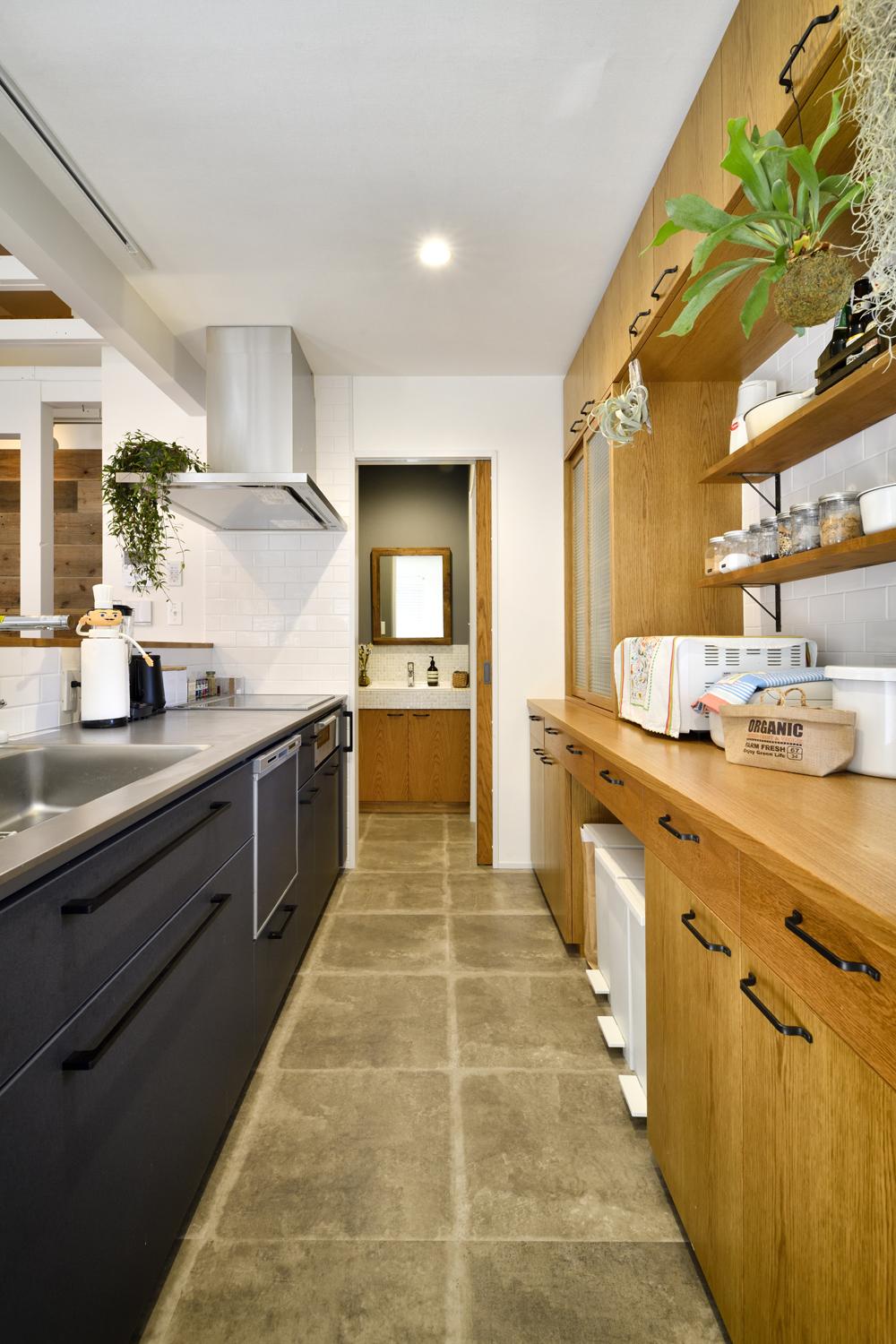 キッチンはリビング・ダイニングが見渡せる対面式に。背面にはたっぷりの収納を備えた造作家具でオープンスタイルでもスッキリと。トイレ用手洗い場とつなげた回遊動線で家事もスムーズ