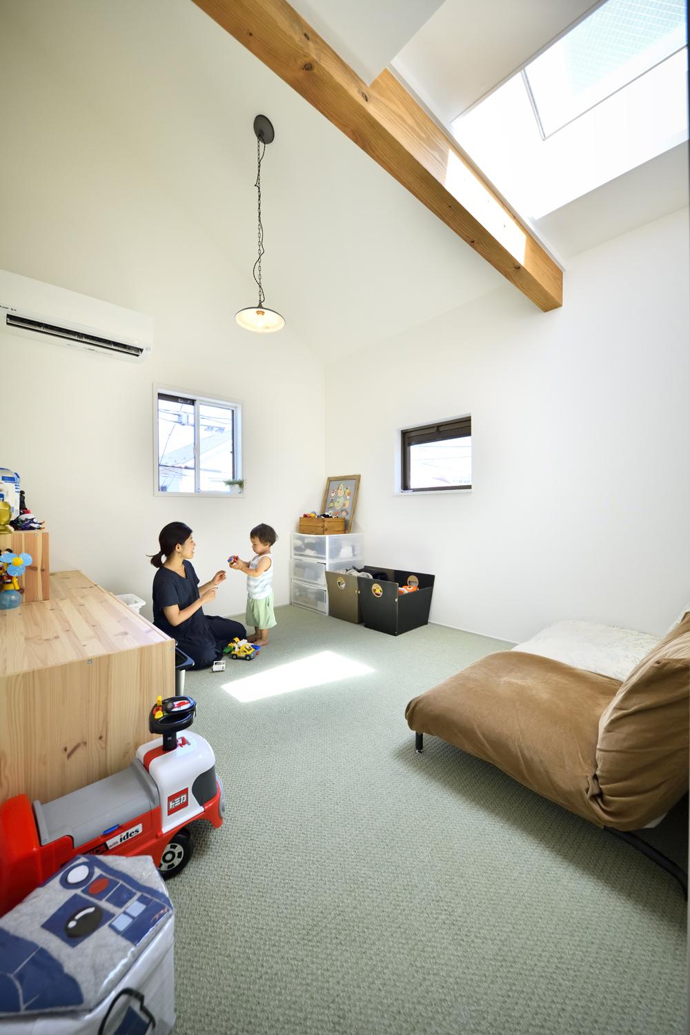 子ども室は階段室の吹抜けの床を造作して広さを確保するとともに、階段室のトップライトを取り込んで北側でも明るい空間に。床には足触りのよいカーペットを採用。淡いグリーンが優しく爽やかな印象を演出