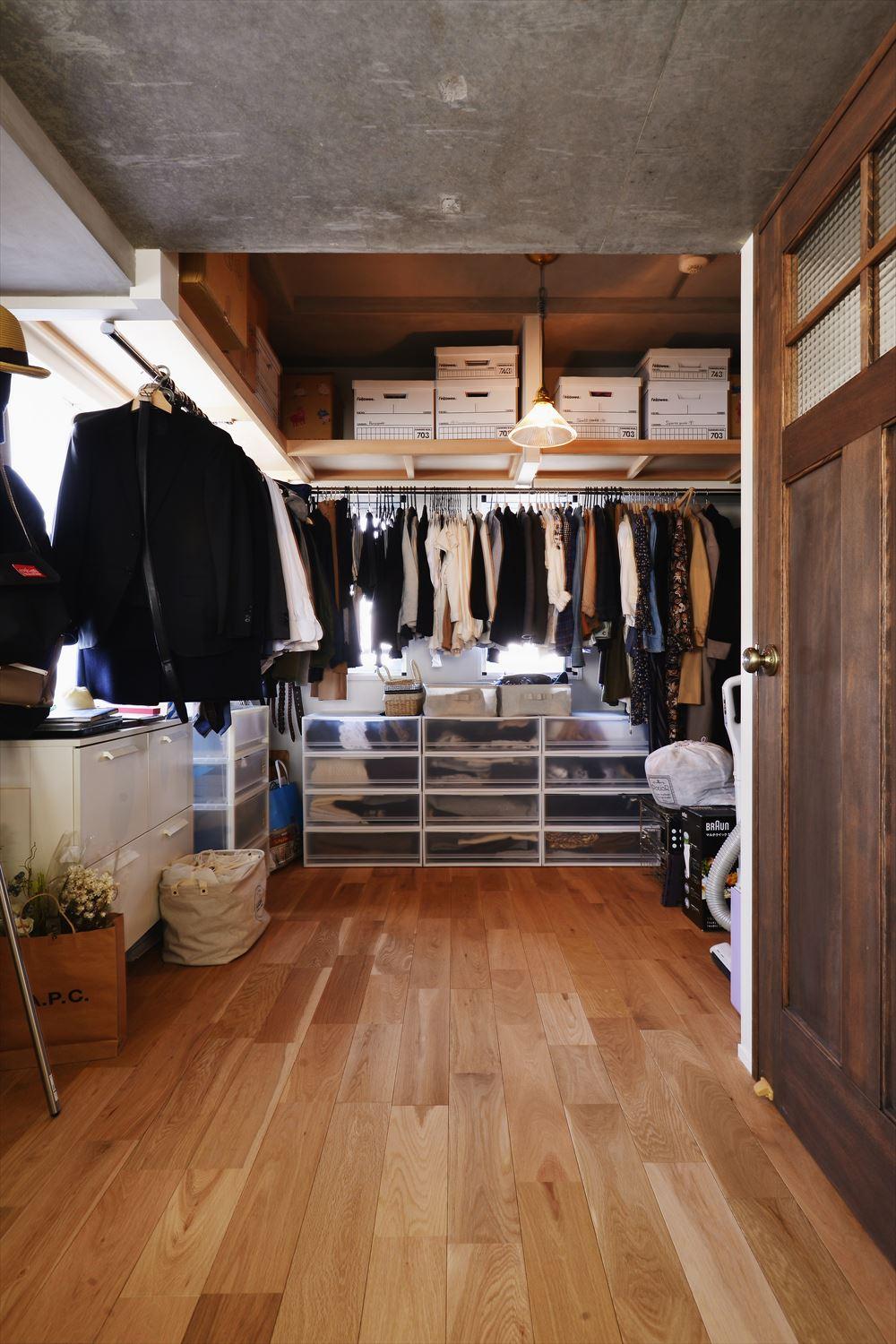 もうひとつの居室は寝室と間仕切りなしでつながる大型WICに大変身。以前の家でしまい切れずにいたモノがすっきりと収まるようにハンガーパイプや棚を設計。レトロ調に仕上げた扉を開けると、玄関ホールにつながる