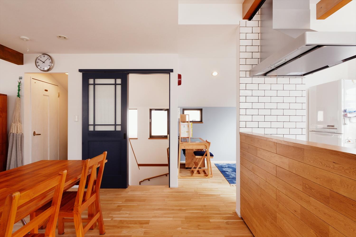 2階はキッチンがフロアを分断していて窮屈な空間でした。そこで以前のリビング側へ大移動。視線の広がる道路側の洋室をリビングに取り込み広々とした空間を確保。対面キッチンから全体が見渡せ、横にはスタディスペースも実現。玄関周りは靴箱をオープン棚にし、広さはそのままでも開放感のある玄関土間を実現しています。