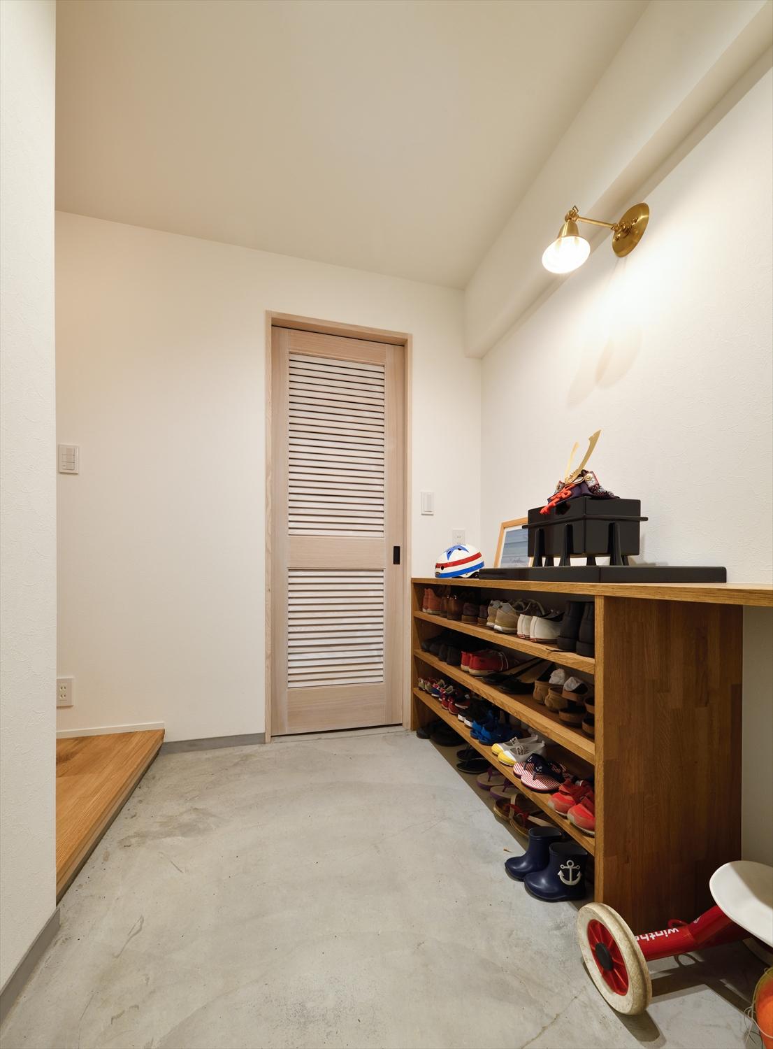 玄関は既存の収納を撤去し、廊下部分まで土間に取り込みながら大型SICを実現した。アウトドア用品などもすっきり収まる広さを確保している。普段使いの靴はオープン棚へ。広々とした土間には子どもの自転車やベビーカーも置いておける。トイレを移動して廊下をつくり、S字型だった廊下もシンプルになった