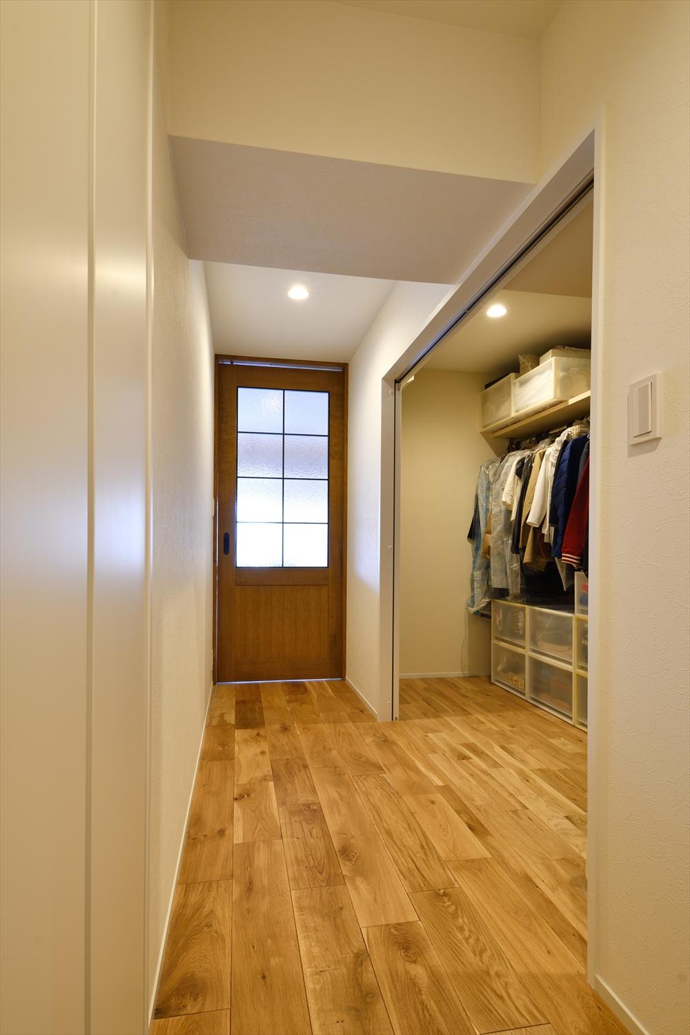 既存の廊下の一部と洗面室だった部分を使って大型WIC（ファミリークロゼット）を実現。ハンガーパイプと枕棚のみをL字型に設置し、将来の使い方に合わせてフレキシブルに対応可能な大容量の収納スペースとなっている