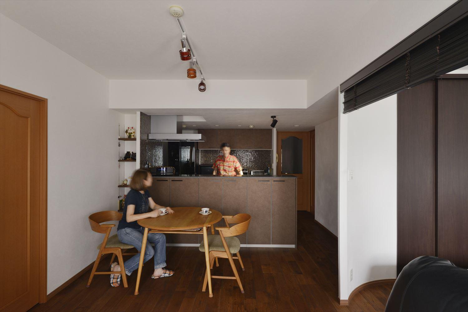 袖壁や下がり壁を撤去し、フルオープンとなったキッチンがLDと開放的につながり、夫婦の会話も弾む。ダイニング側にもたっぷりの収納があり、テーブルに座ったまま必要なものを取り出せる。ガスレンジ脇のデッドスペースを活用して棚を設置。ダイニング側は飾り棚に、キッチン側は隠せる収納となっている