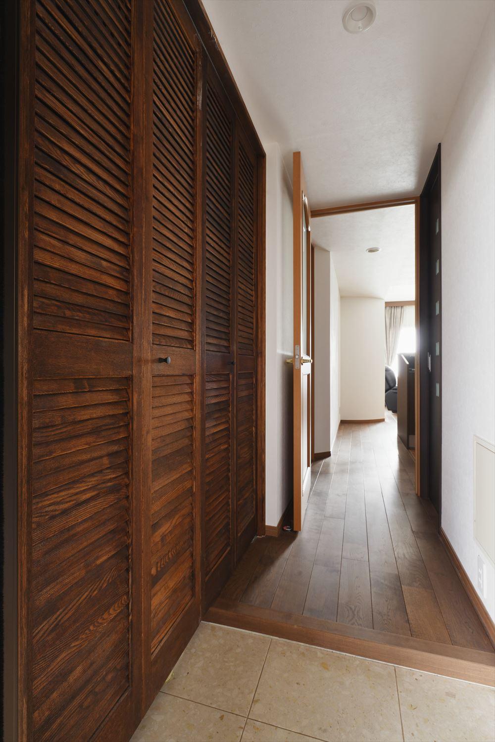 土間タイルは既存を利用。フロートタイプだった靴収納は全面収納に変更し、収納力をアップ。収まりきらずに溢れていた靴がスッキリ片付いた。ルーバー扉は塗装でバリをイメージした色合いに。対面のSIC内にもたくさんの棚を設えて容量と使い勝手が向上した