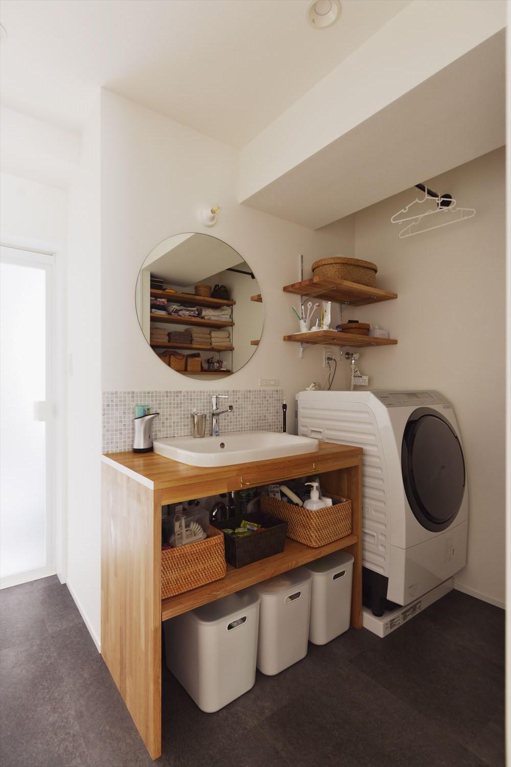 洗面室は以前よりコンパクトになったものの、機能性は充実。シンプルな造作洗面台はオープン棚で使いやすく。モザイクタイルをあしらい、丸鏡で可愛らしい雰囲気に。ちょい掛けできるアイアンバーを要所に取り付けた