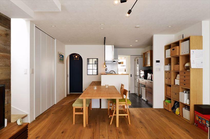 2階のLDK。キッチン前にカウンターを設置してスタディスペースに。ブルーのアクセントクロスと星型のライトが可愛らしいアール開口からトイレ、洗面室につながる。