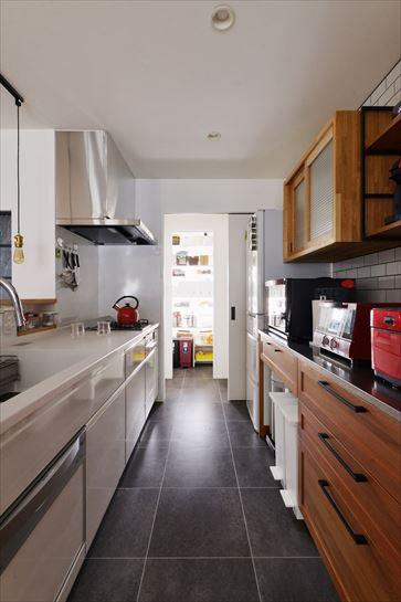 キッチンは清潔感溢れるホワイトをセレクト。立ち上がりのスパイスニッチが便利。ダストBOXもスッキリ収まるカウンター収納や吊り戸棚、シェルフは使い勝手に合わせて造作したもの。引き戸で仕切れるパントリーからも洗面室に行ける回遊動線を実現。いつもお子さんが走り回っているそう