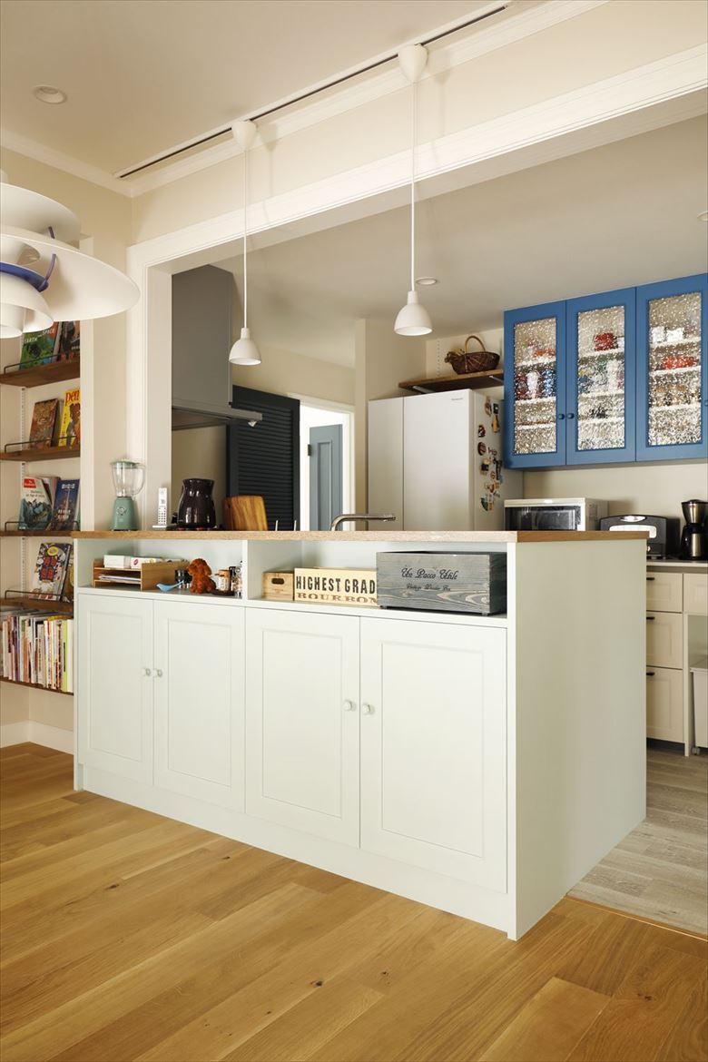 独立していたキッチンを移動してダイニングと対面するオープンなキッチンに。キッチンカウンターの淡い色味と、後ろの収納棚のブルーのコントラストはだんな様のお気に入り。