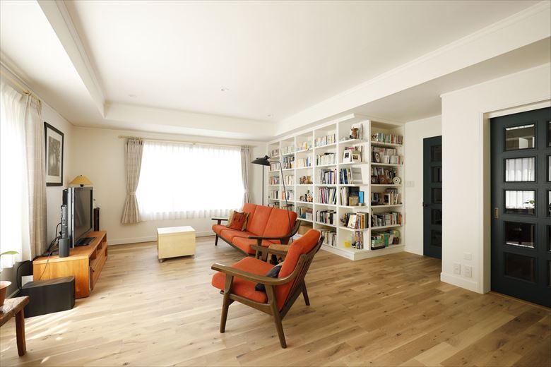 リビングは既存の広さを活かした。奥に造作した本棚は古き良きアメリカをイメージしたデザイン。1階はほぼ全面床暖房を入れているが、リビングの床だけは本物の無垢材にこだわり、床暖房をあえて入れず、アンティークな色味に塗装したオーク無垢材を採用。