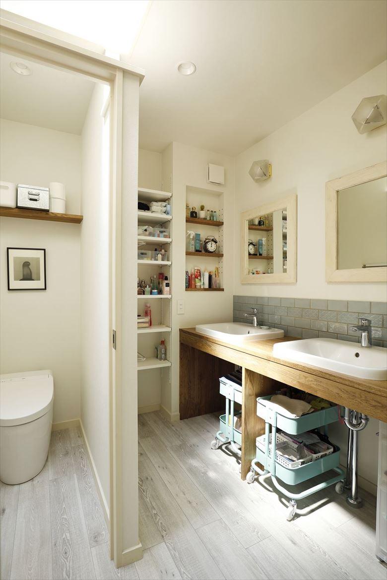 2階の主寝室専用だったサニタリールームは入り口を変えて共用に。内部の浴槽は撤去して、個室のトイレと洗面台に分けた。洗面台は奥様用と娘さん用の2ボウルを用意して下部はオープン収納に。壁面はニッチや棚を設けて使い勝手よく。