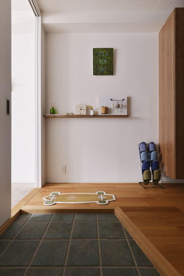 玄関はポーチを広げてドア位置を内側へ移動。さらに土間も大きく取って広々とした玄関スペースを確保した。このアイデアが依頼の決め手となったそう。玄関ポーチには予備室からの光が届く窓を取り付け、明るさをもたらす工夫も施されている。