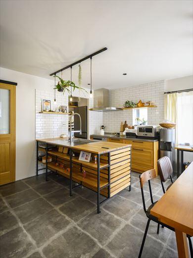 無垢の木を使ったキッチンはパントリーに行き来しやすいII型を採用。シンク側は格子とアイアンで構成されたフレームタイプを選んだ