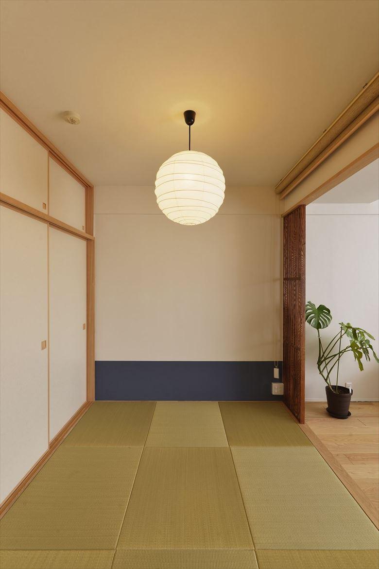 夫妻の寝室として活用している和室は必要最小限のスペースに。押入れを移動して廊下側からWICに出入りできるようにした。枕元に藍色のアクセントを施し、障子戸やすだれ風のロールスクリーンでほんのりと和が感じられるインテリアを実現。普段は仕切りを開け放してリビングの一部として活用