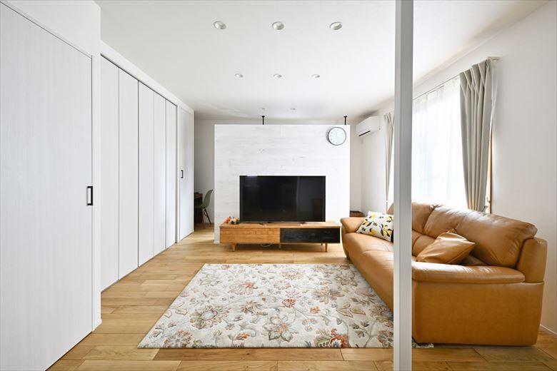 リビングの床は高級感がある幅広タイプのオークの無垢床。既存フローリングに上貼りすることでコストを削減。テレビの裏にはワークスペースを設けた。