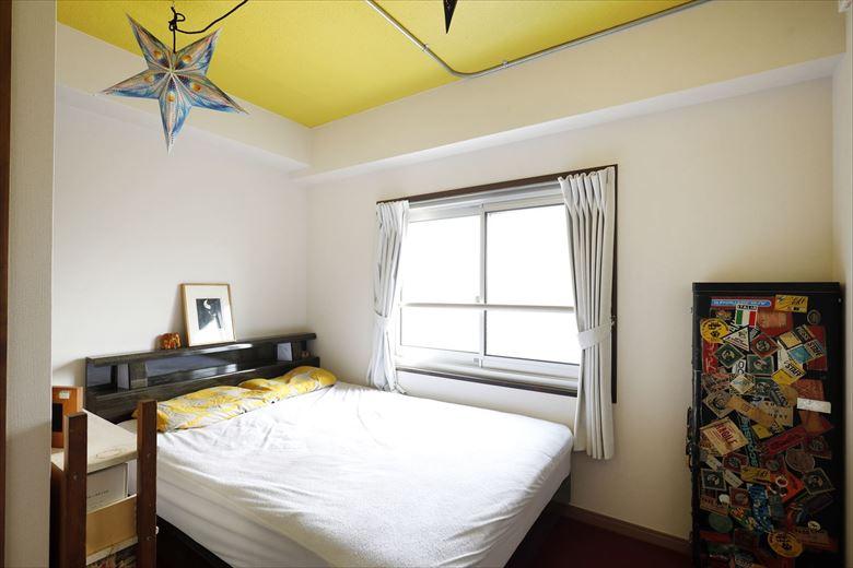 寝室は内装を一新。床は防音下地を入れた二重床の上にえんじ色のカーペットを敷いた。天井は爽やかな気分で目覚められそうなイエローに。洗面室の新設や収納の拡大によってスペースは小さくなったが、洗面室との仕切り壁に室内窓を取り付け、壁の圧迫感を軽減している。各窓は施主手配でサッシを入れ替え、断熱性能を高めた