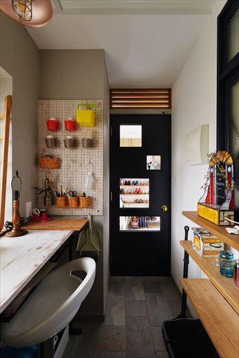 玄関から寝室に沿って土間を伸ばし、奥様の趣味であるステンドグラス製作用のワークスペースに。出入り口に取り付けた造作のドアには大小の開口があり、製作したステンドグラスを簡単にはめ込むことができる