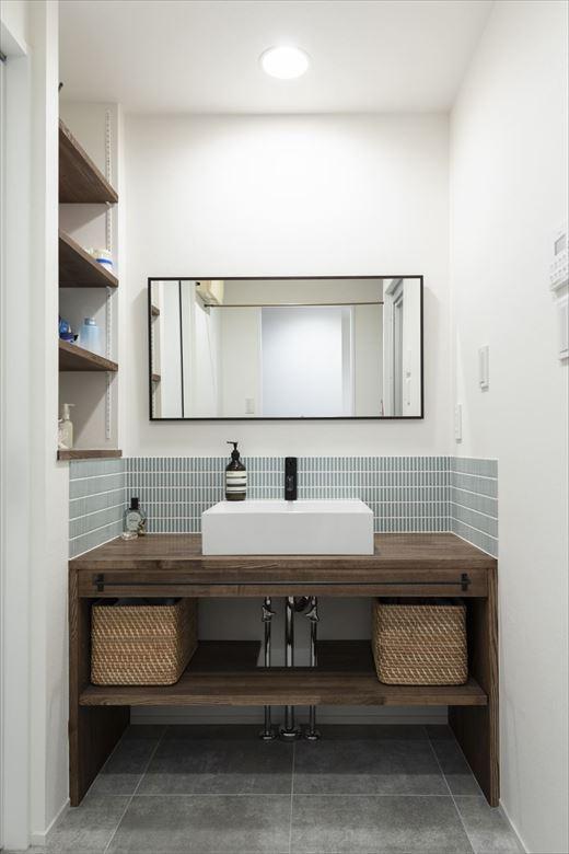 シンプルなデザインの造作洗面台。たくさんモノが置ける可動棚も新たに新設。キッチンとつながる動線はそのまま活かした