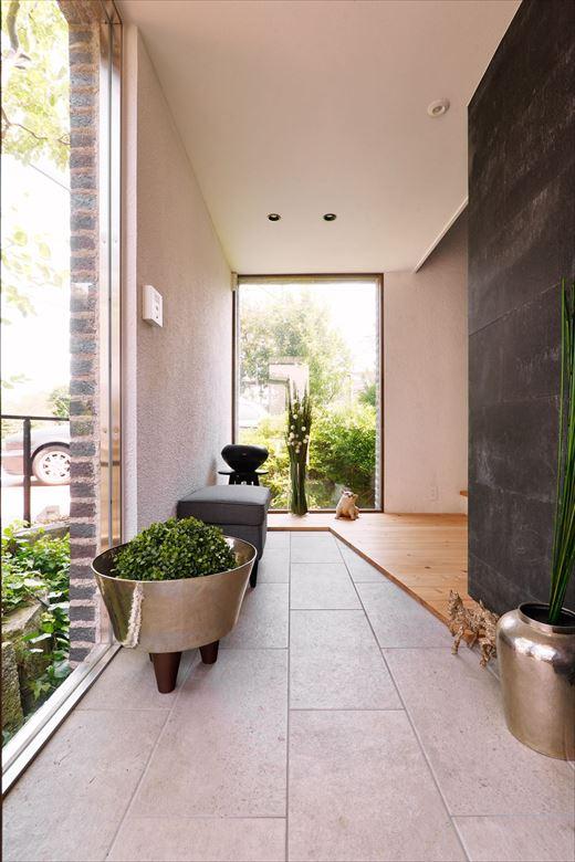 土間を広げた玄関ホール。夜には外に設置したスポットライトでシンボルツリーをはじめとした木々が浮かび上がる。その様子はまるで美術館のよう。
既存の窓にガラスを追加し、断熱性にも配慮