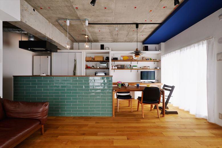 現しにした天井のコンクリートや無垢のフローリングなど、素材感を生かした印象的なLDK。ダイニングの一角には、在宅ワークの為のデスクカウンターを造作。カウンター上の壁面にはシェルフを取り付け、ちょっとした収納スペースに