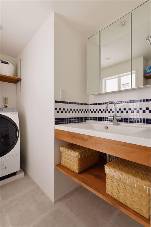 さわやかなタイル使いが目を引く洗面室。広さやレイアウトは大きく変えず、カウンター周りに好みの素材とデザインをとり入れた