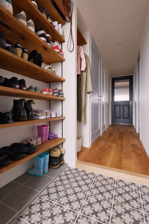 玄関では壁一面を収納スペースに。靴棚の隣にはアウターなどをかけておけるクローゼットスペースも。靴棚はブラインドでさっと目隠しできる