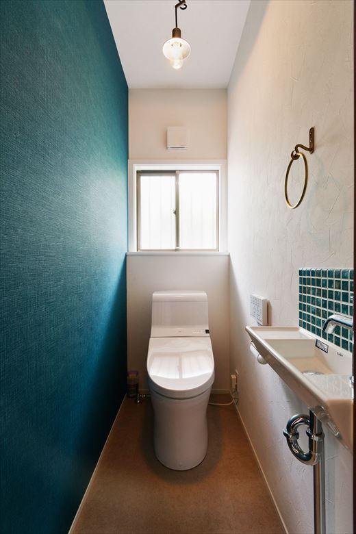 ２階のトイレは設備を交換して新たに手洗いを設置。正面の壁と手洗いのタイルにブルーカラーを用いてアクセントに