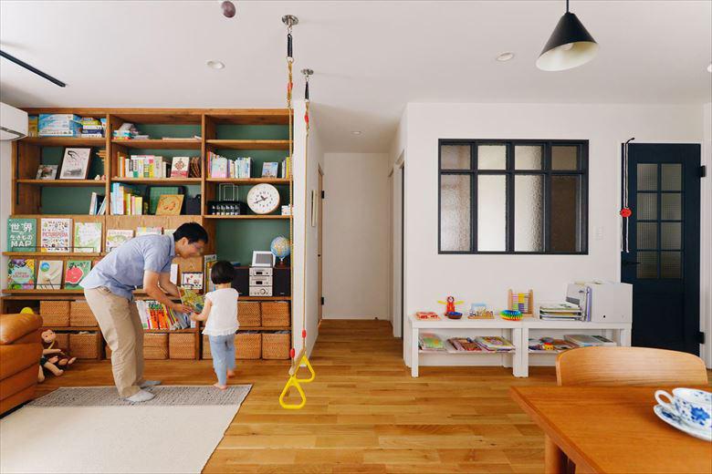 絵本が飾れる造作の本棚や、背面に使ったグリーンのアクセントクロスは奥様のイメージを叶えたもの。模様ガラスを使った室内窓やリビングドアで子世帯スペースを区切った